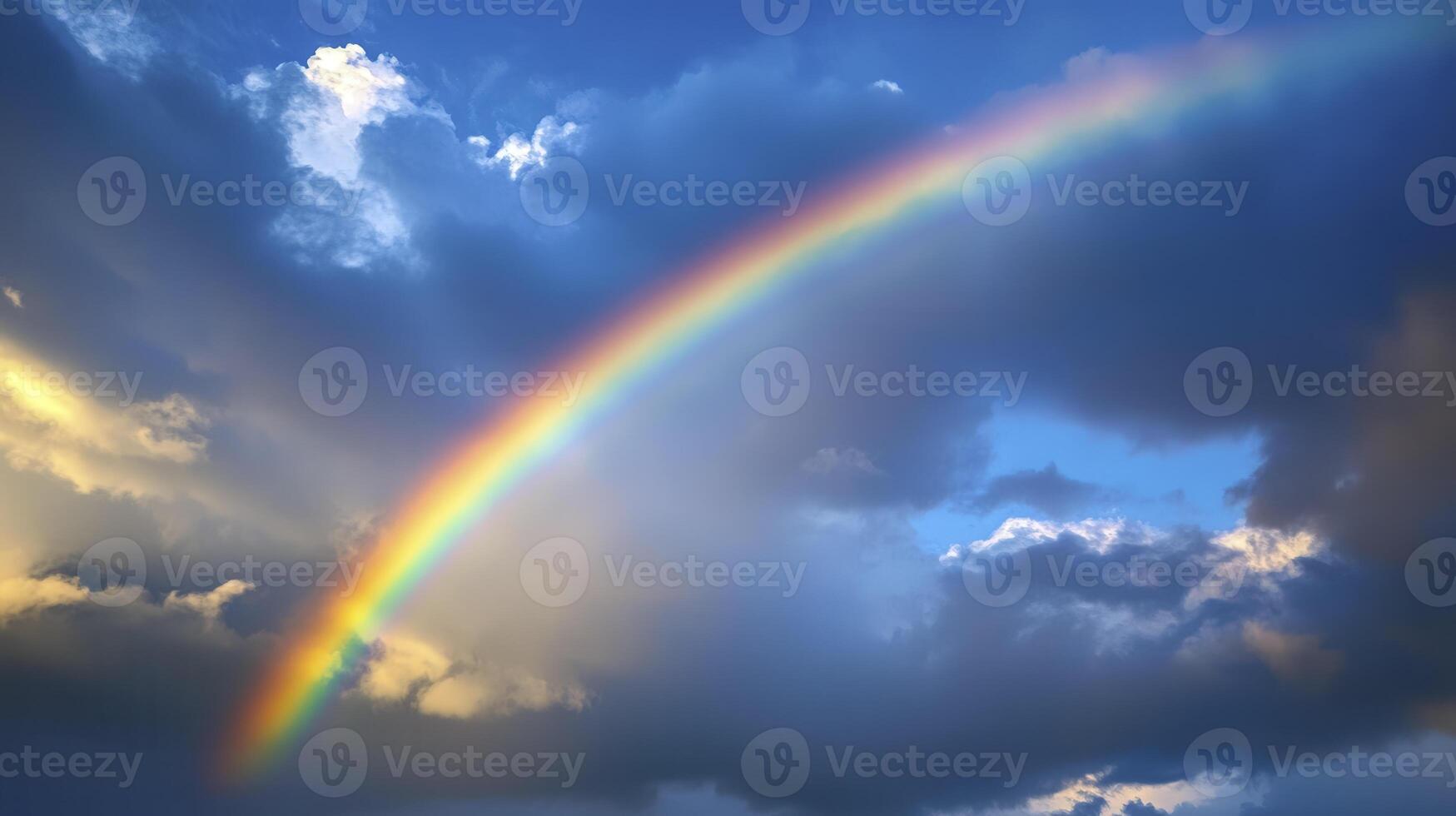 A vibrant rainbow arches across a cloudy sky after the rain, casting colors over the landscape at sunset photo