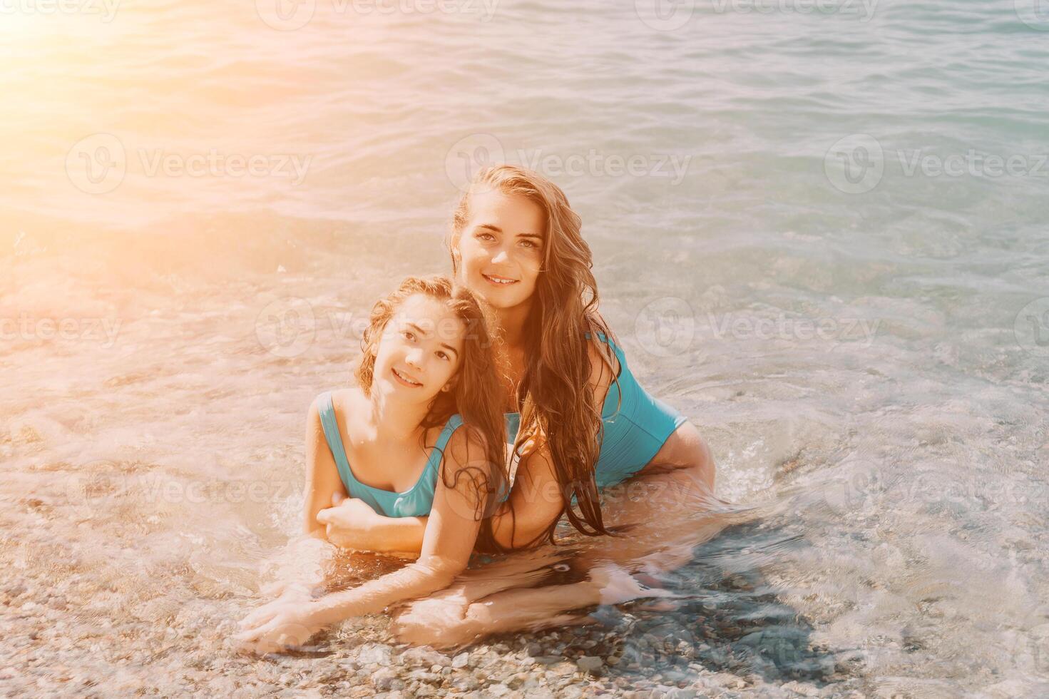Two Women in Blue Swimsuits Smiling in the Sea photo