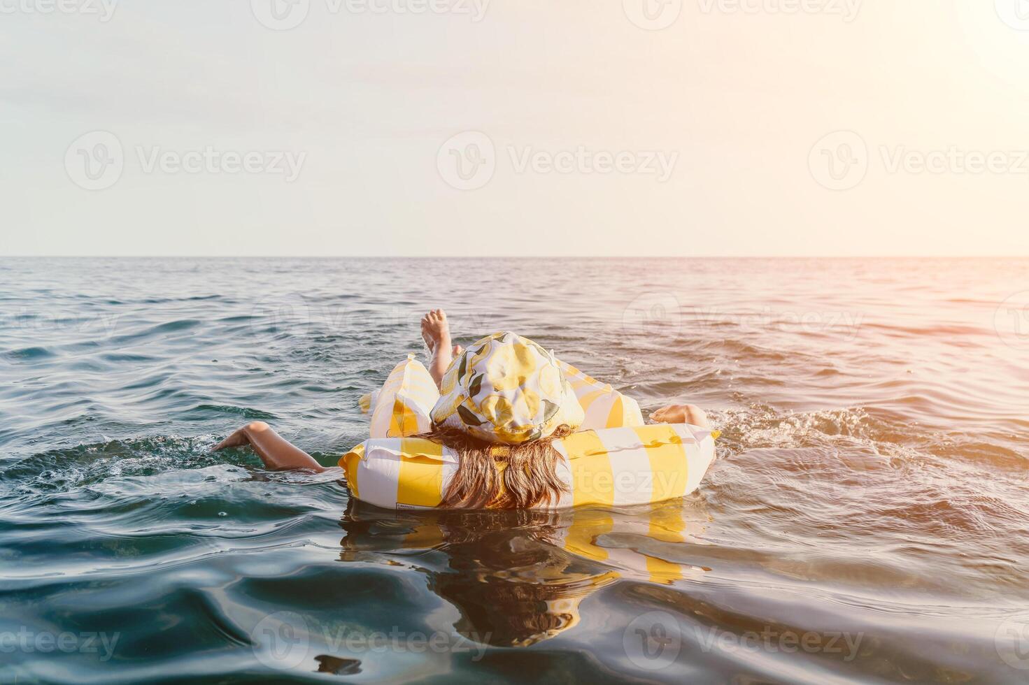 Woman Inflatable Ring Ocean - A woman floats on an inflatable ring in the ocean on a sunny day. photo