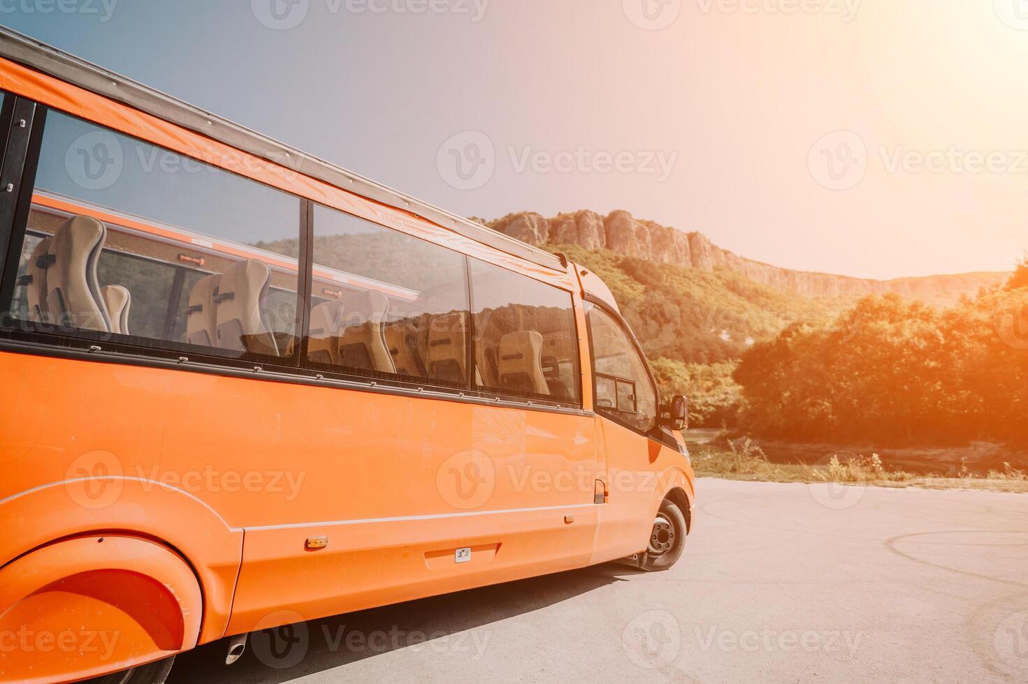Bus, Mountain, Landscape - Orange bus parked on a road with mountain in the background. photo