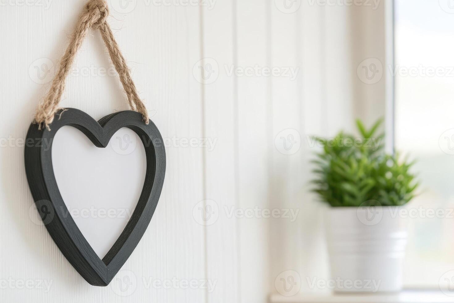 Photo frame of heart shape for mockup design on light wall background.