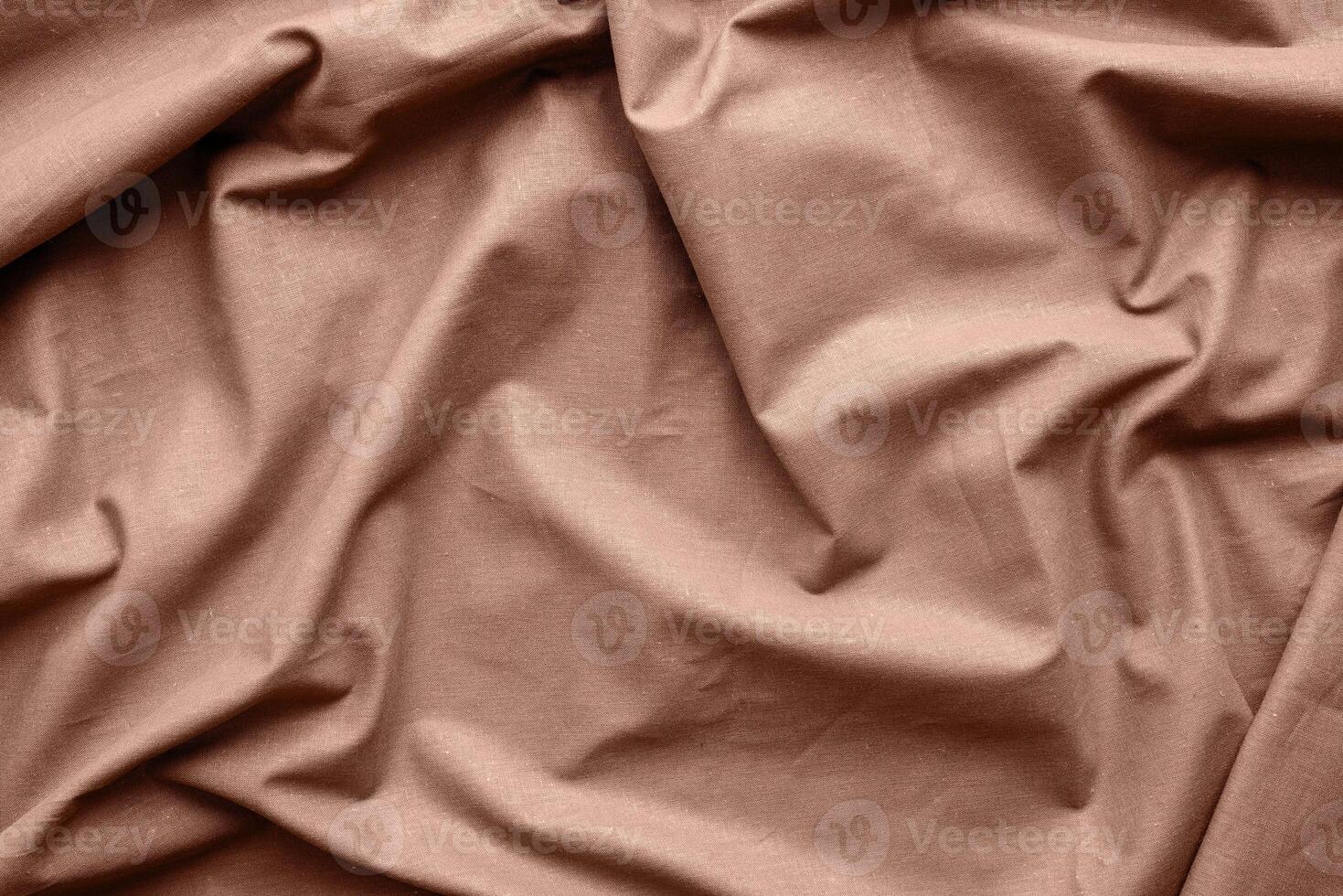 Mocha Mousse - color of the year 2025. Chocolate brown fabric texture background, wavy fabric photo