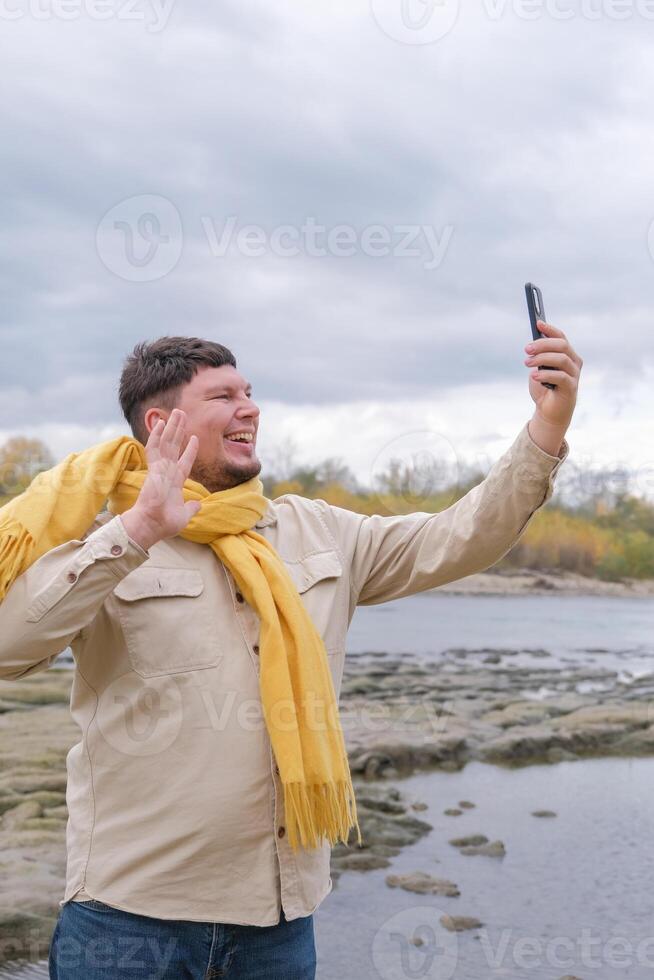 young caucasian man walking in the park and using smartphone photo
