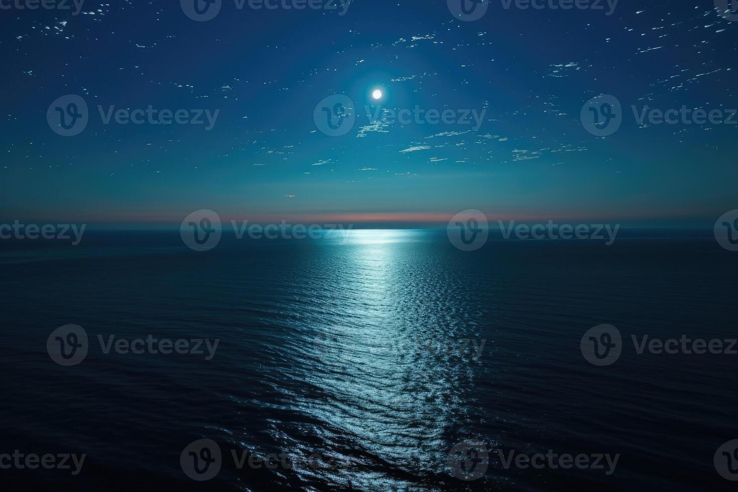 A full moon shining over the ocean at night photo