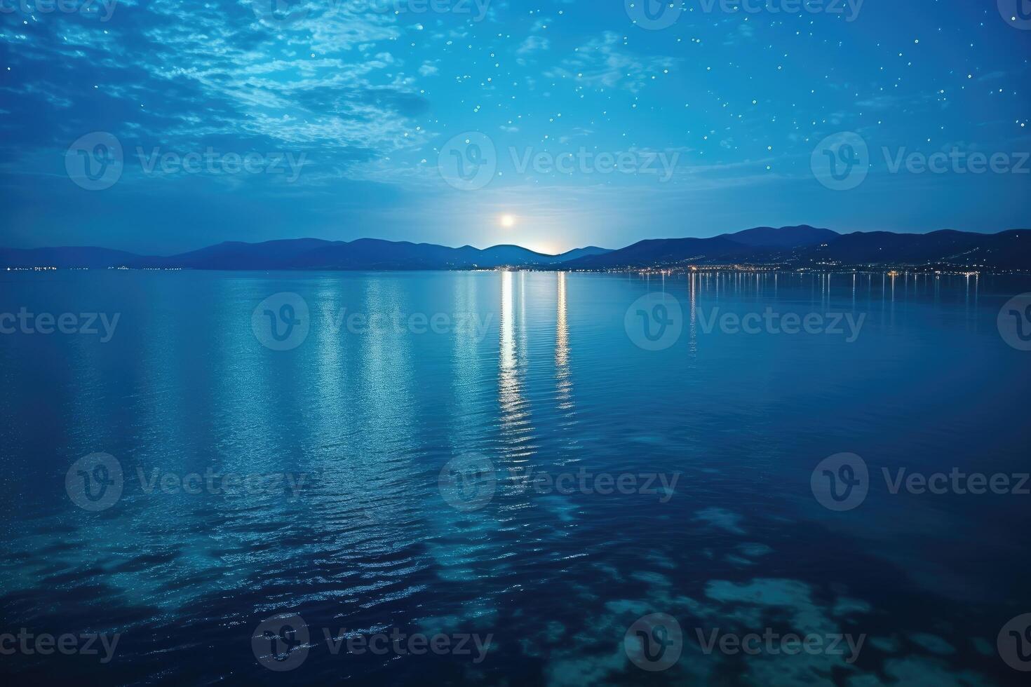 A full moon over the water at night photo