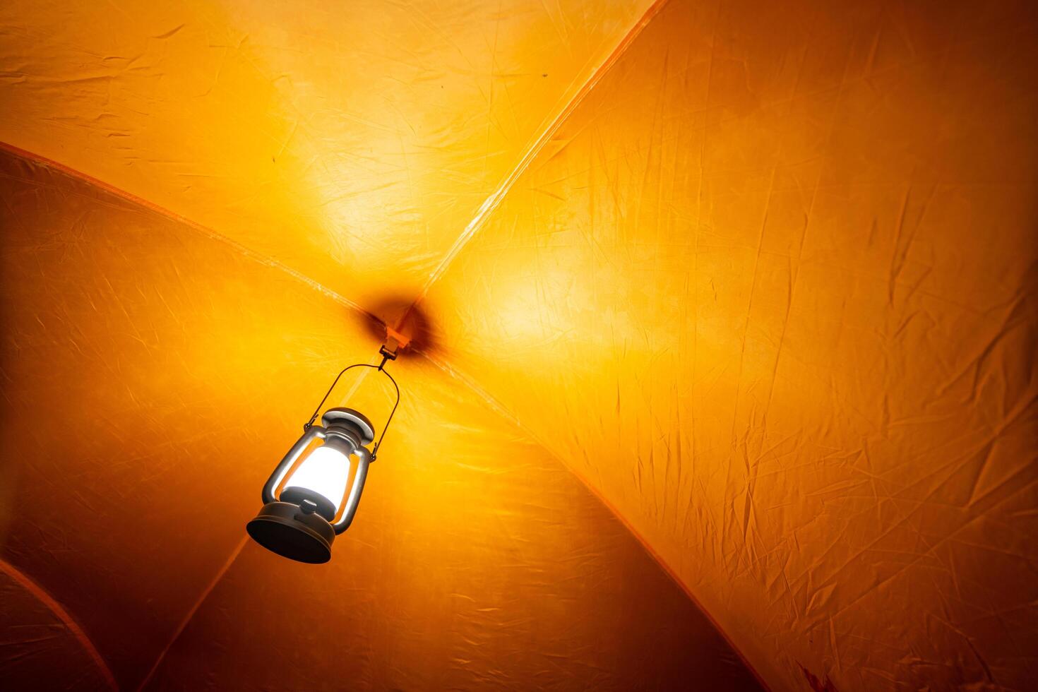 antique lamp Light inside the camping tent at night in the pitch dark forest, selective focus, soft focus. photo