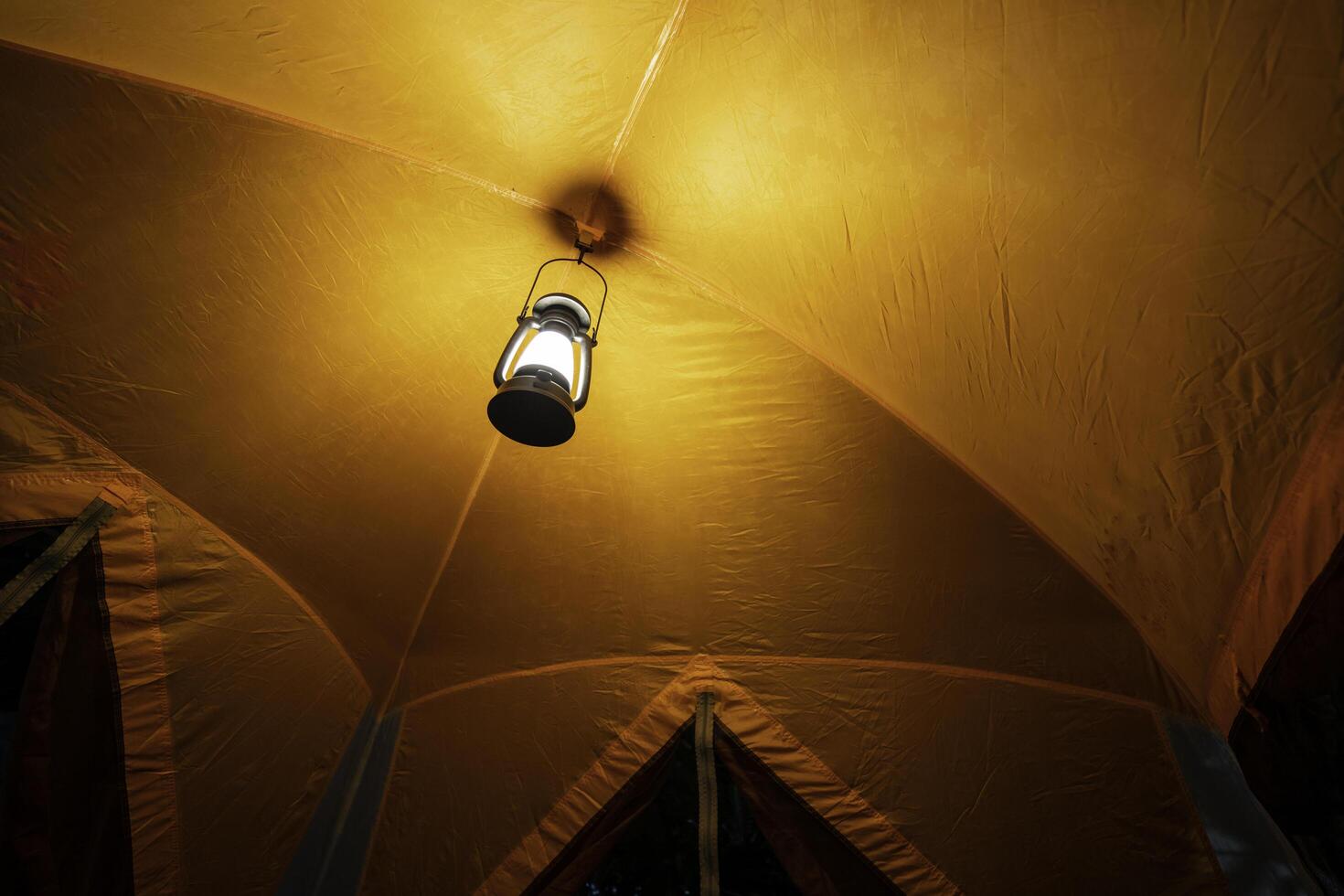 antique lamp Light inside the camping tent at night in the pitch dark forest, selective focus, soft focus. photo