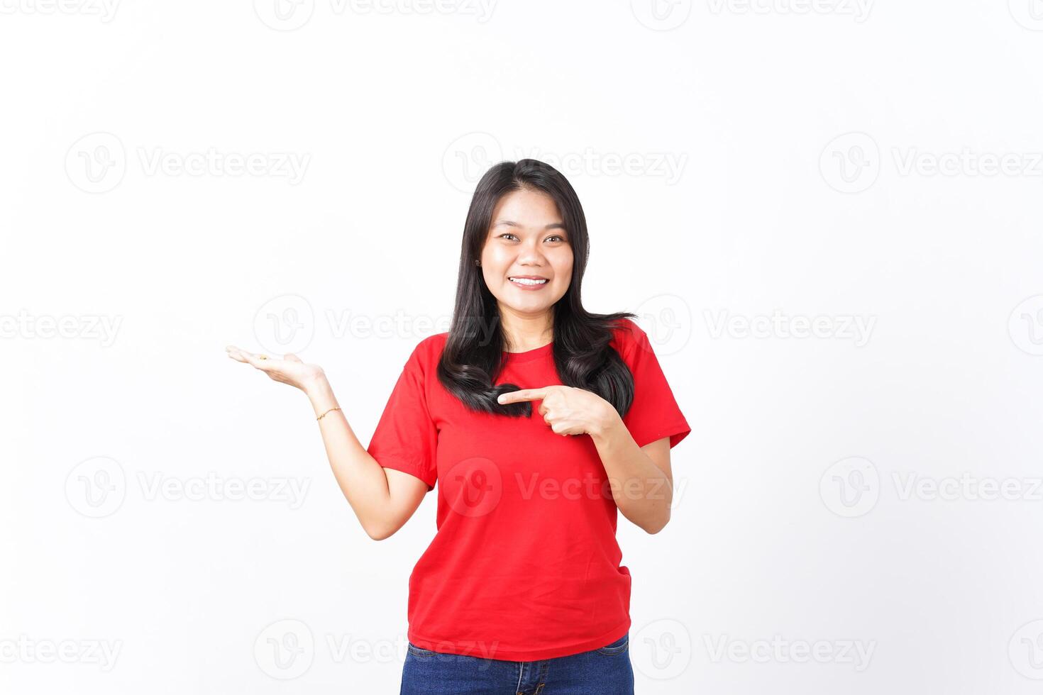 Smiling, Pointing and presenting product for ad on open hand palm Of Beautiful Asian Woman Wearing red shirt Isolated On White Background photo