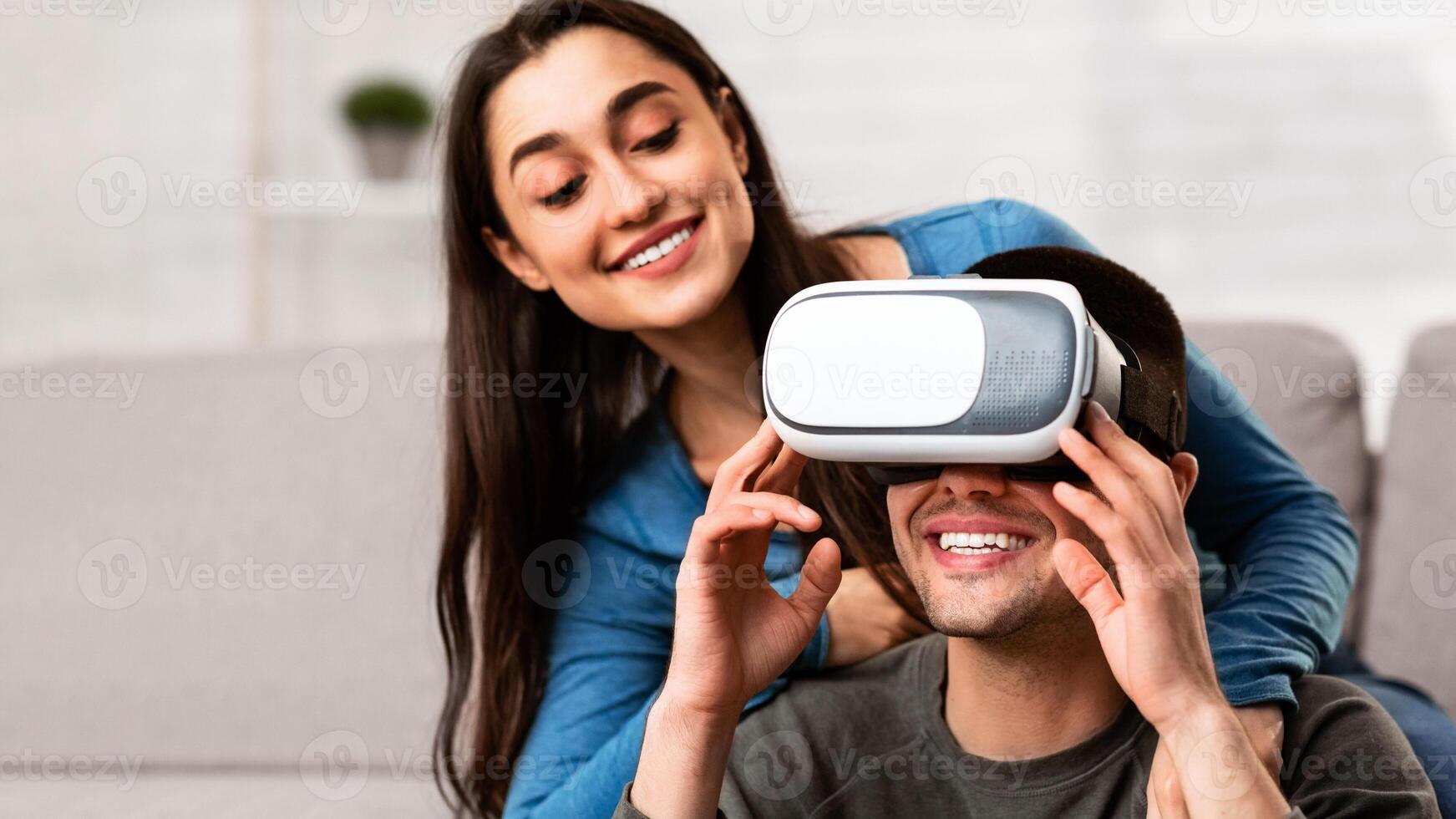 Normal Life In Isolation. Lovely couple having fun, spending time together at home, wearing virtual reality glasses photo