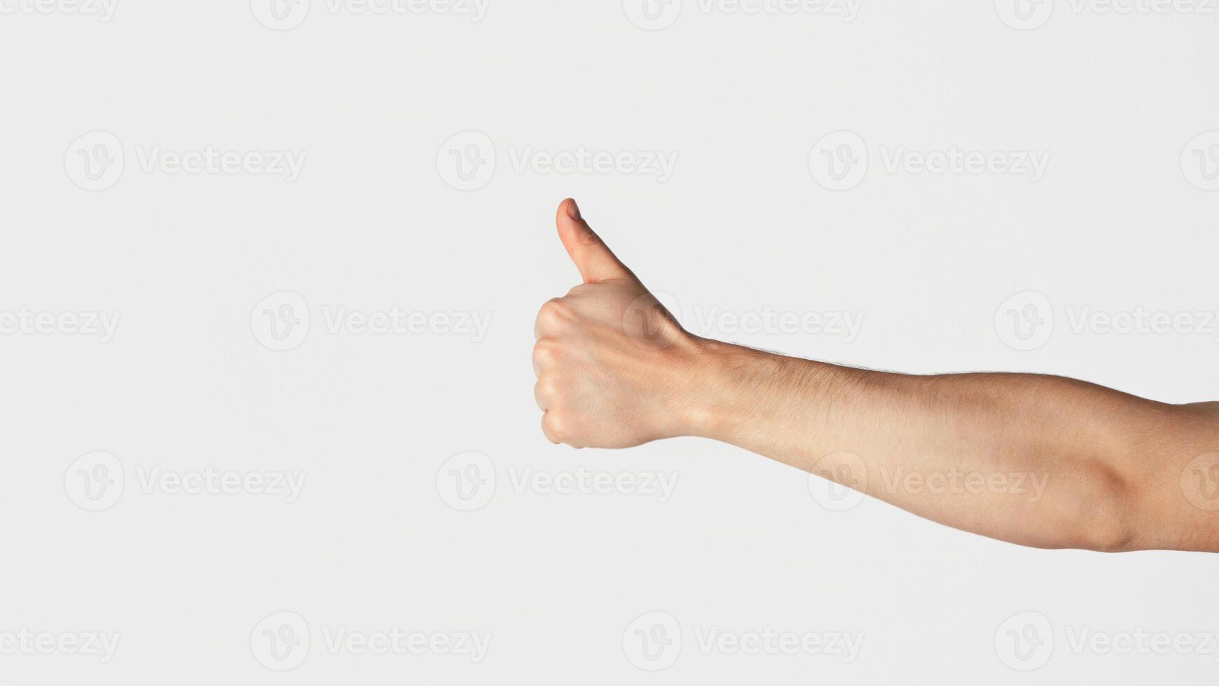 Unrecognizable millennial guy showing thumb up gesture over light background, closeup. Panorama photo