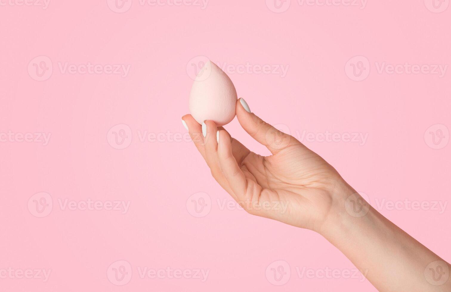 Woman showing cosmetic applicator on pink background, close up of hand. Panorama photo