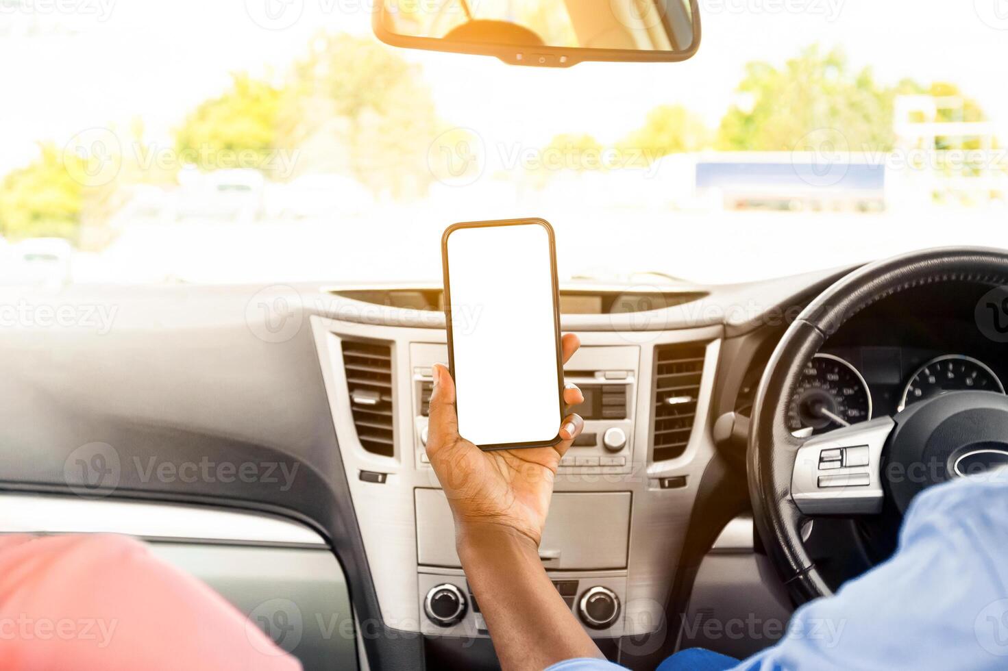 Back rear over the shoulder view of happy black male driver holding smartphone with blank screen, mock up. Closeup of mobile phone with empty display, couple using mobile app for navigation, copyspace photo