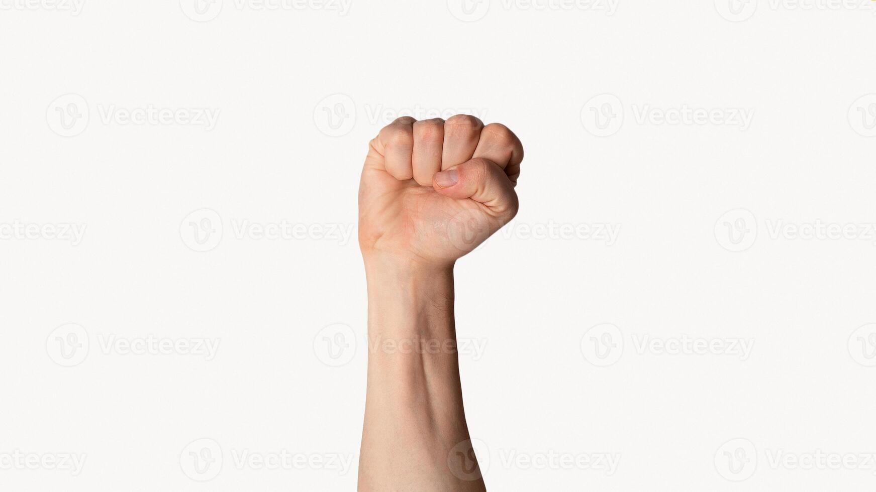 Millennial man raising his clenched fist up over light background, close up view. Panorama photo