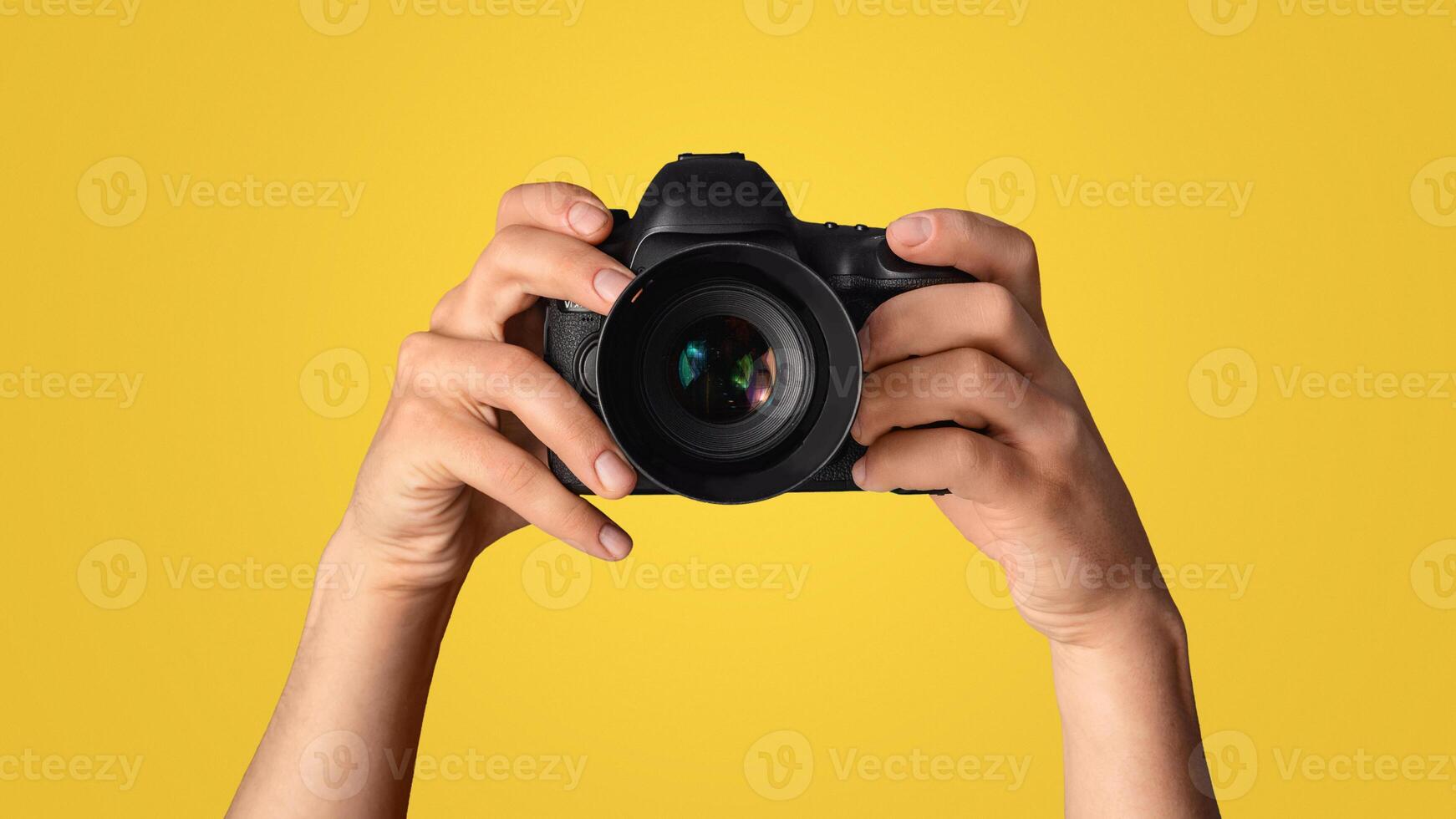 Close up of photographer pointing DSLR camera at screen, blue background. Panorama photo