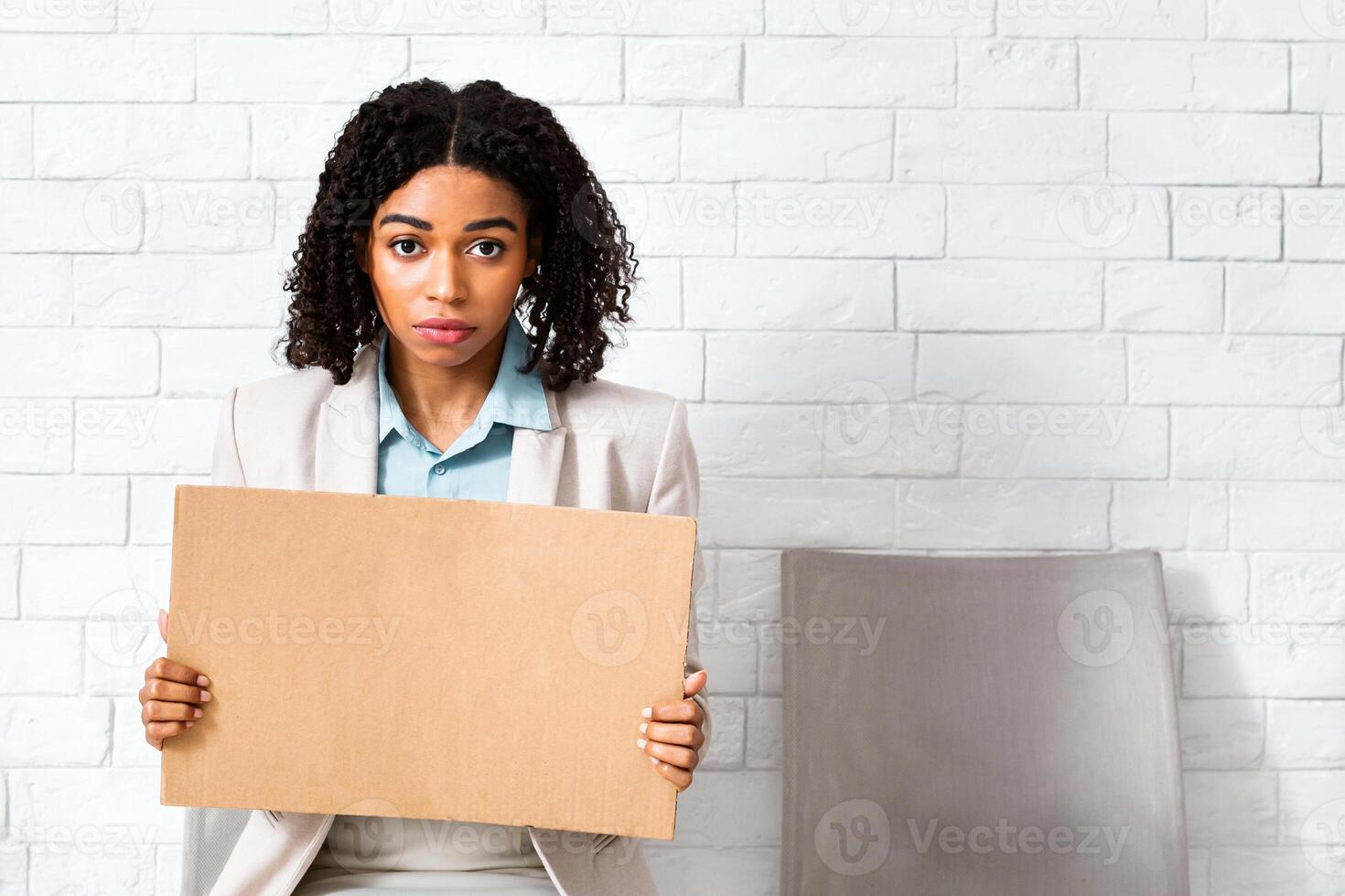Young black lady with blank sign waiting for employment interview at office lobby, space for design. Panorama photo