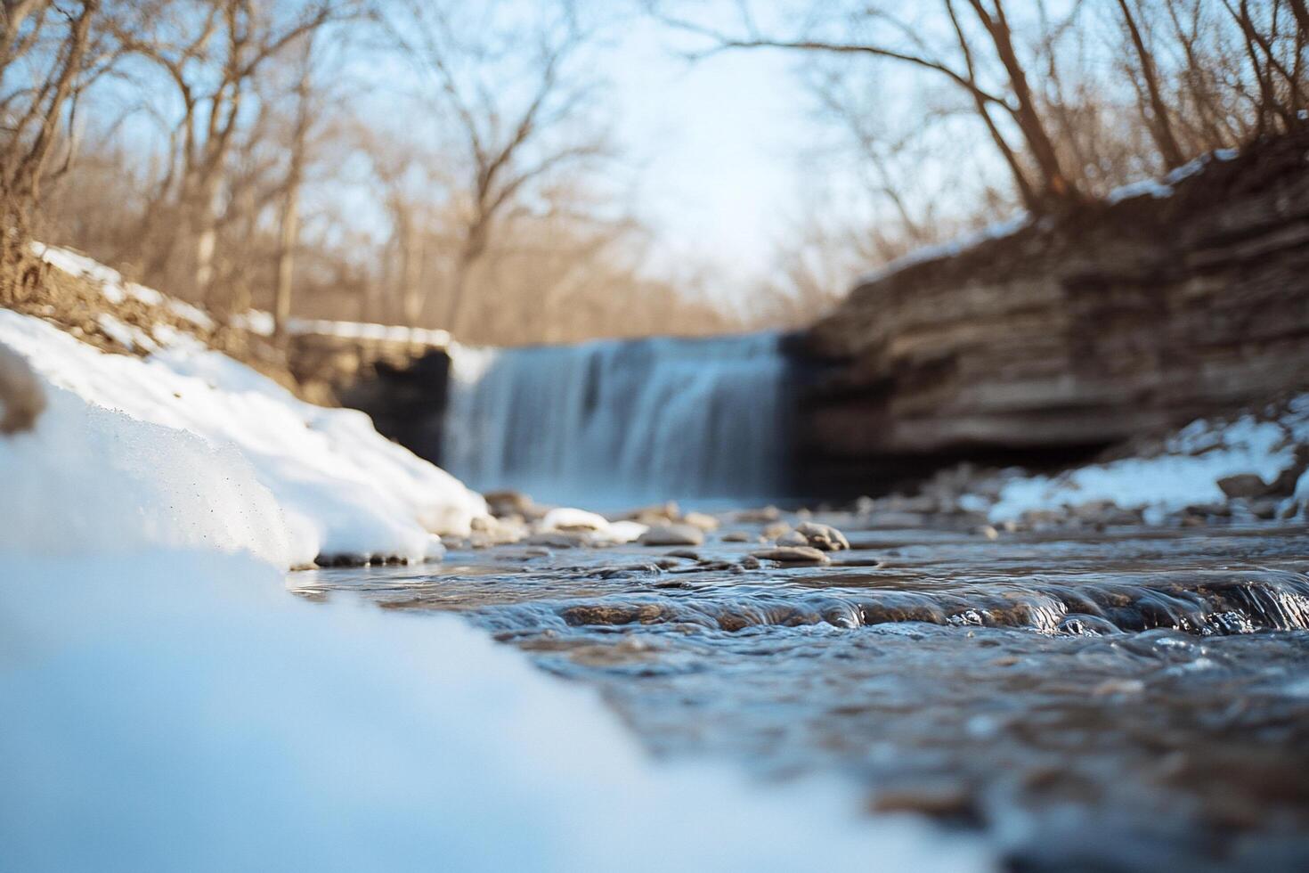 A waterfall in the winter with snow on the ground photo