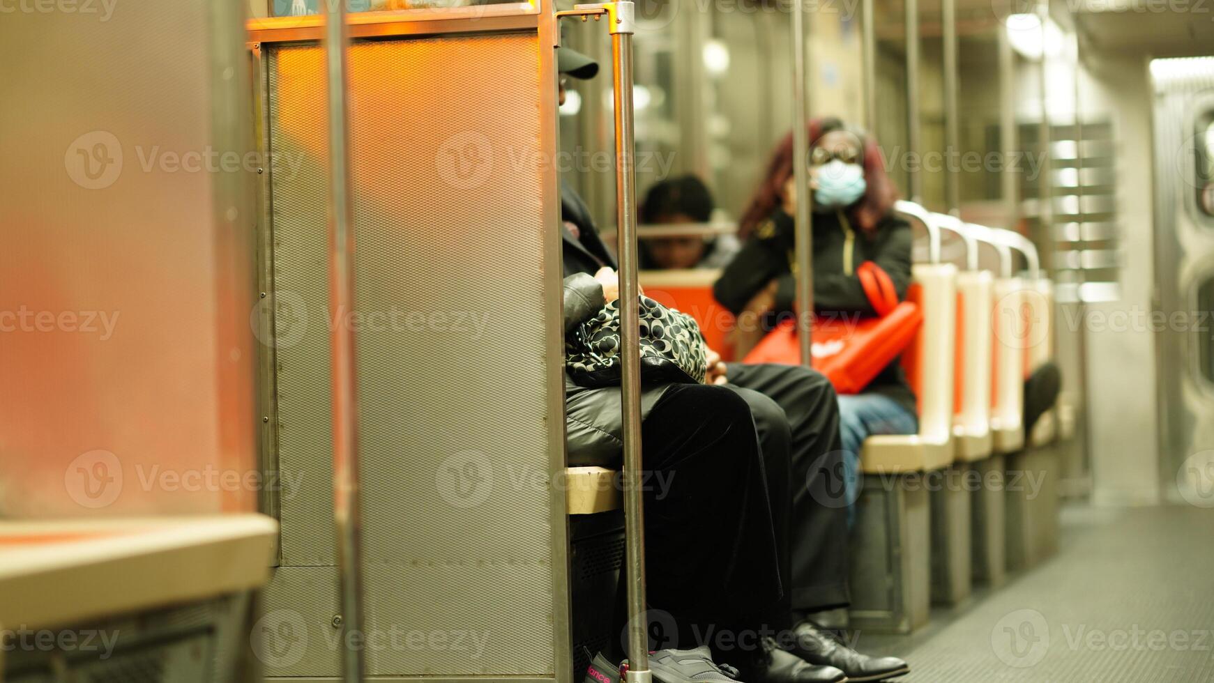 The subway interior view with several peaple sitting on the seats photo