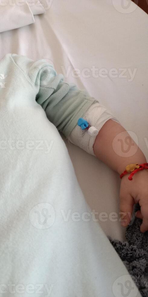 A Child Sitting in a Hospital Bed with IV Access Receiving Necessary Medical Attention photo