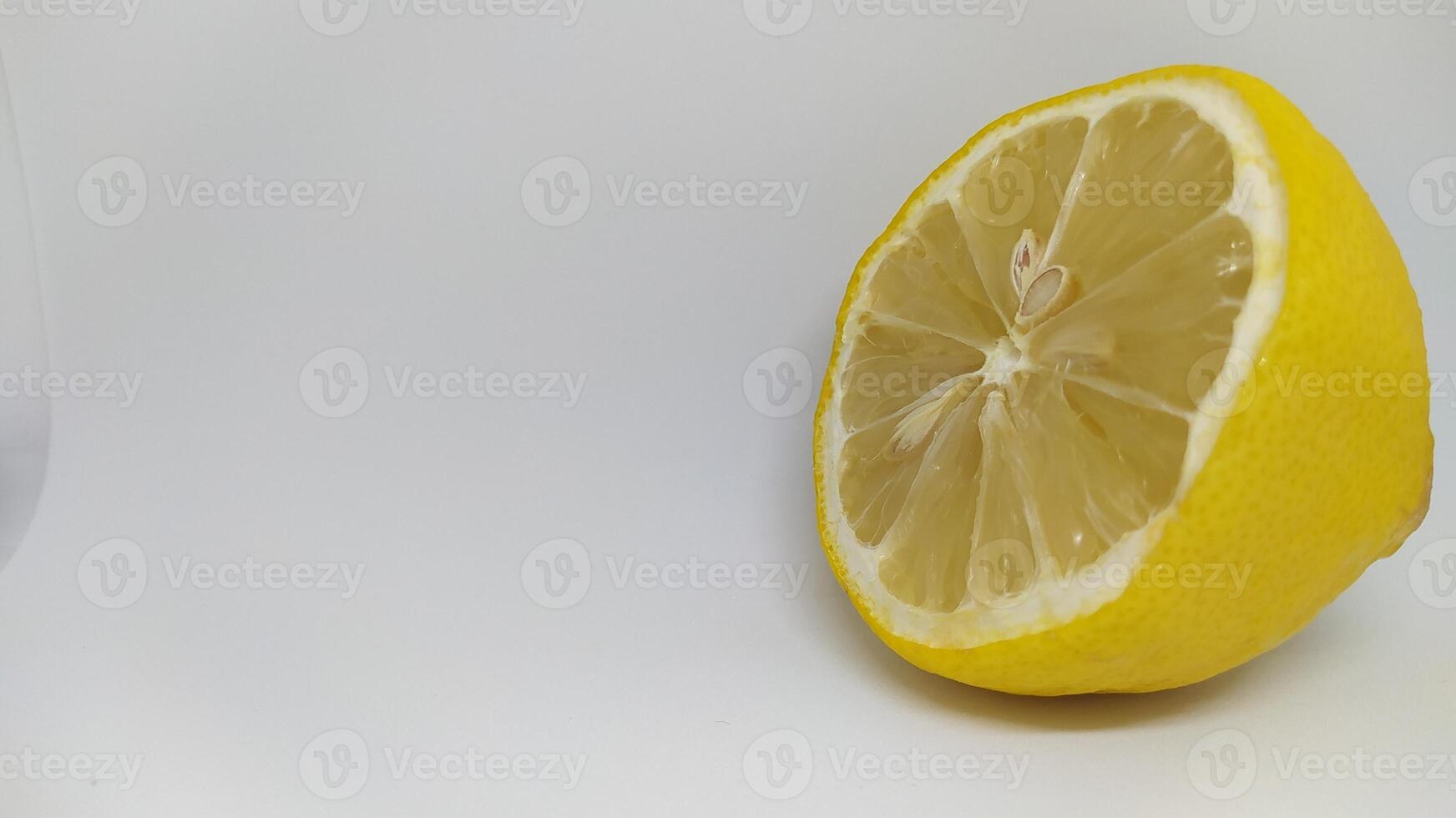 A Fresh Lemon Half Displayed on a Vibrant White Background, Ideal for Culinary Use photo
