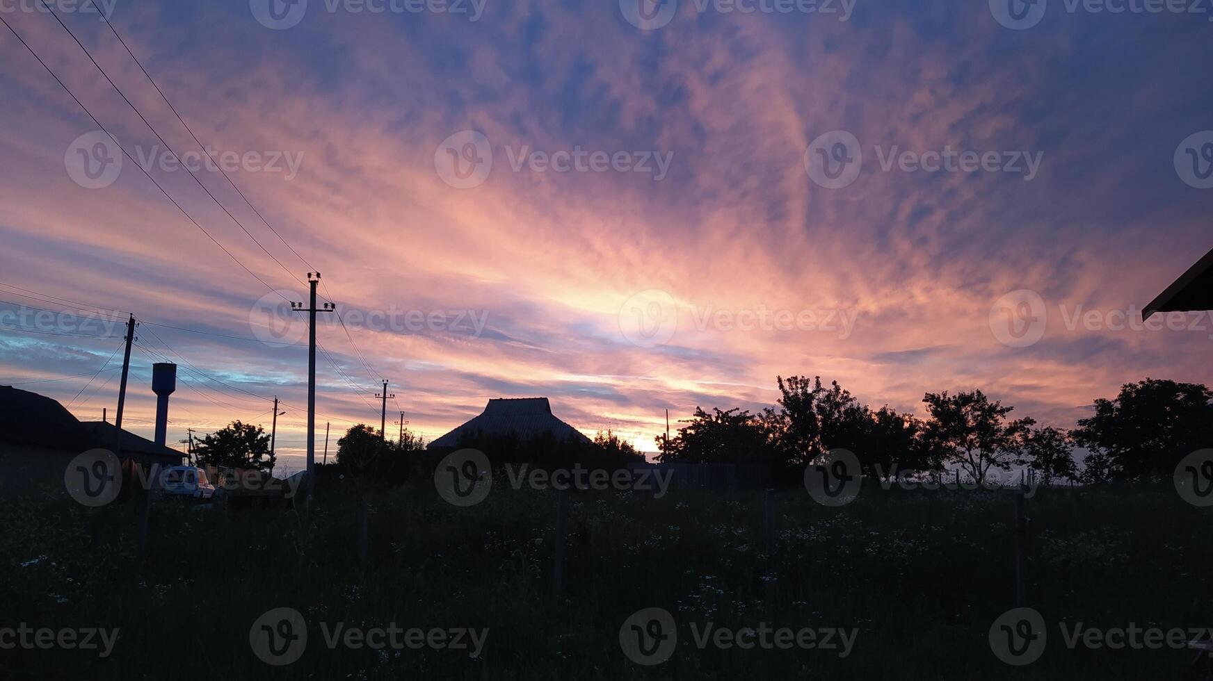 A Stunning Sunset Featuring Vivid Colors Blanket the Tranquil Landscape Below It photo