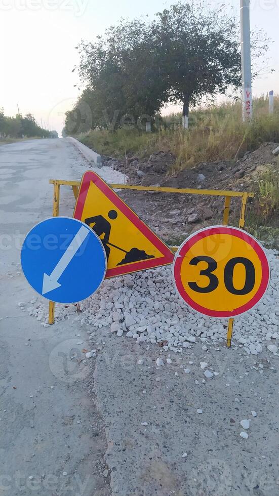 Roadwork signage that indicates the speed limit, as well as the direction for vehicles ahead photo