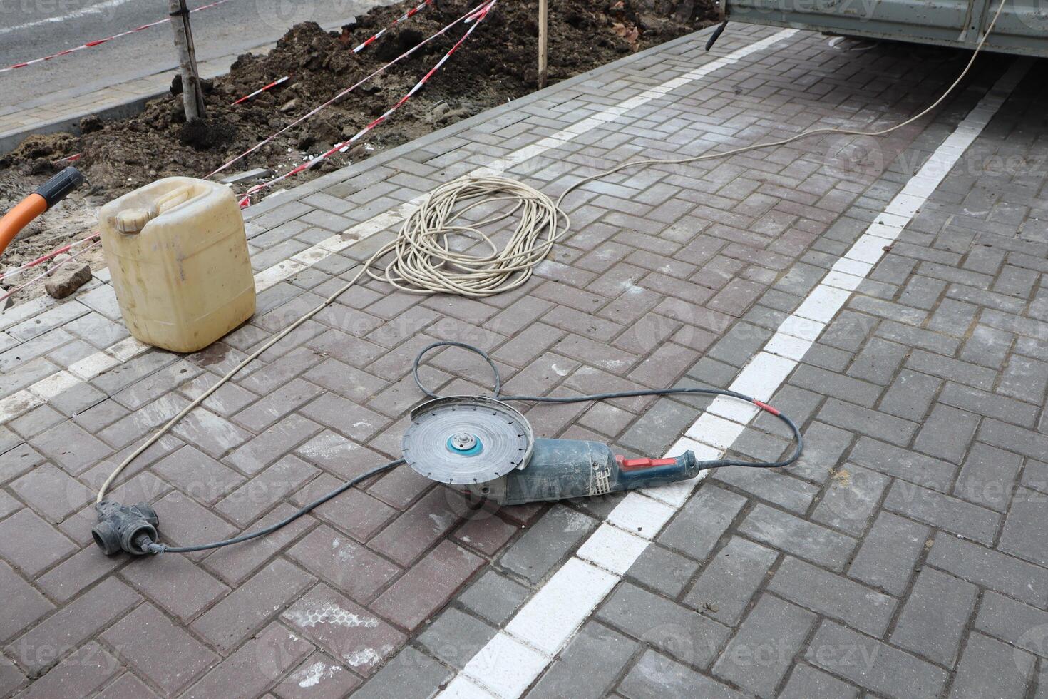 Various Outdoor Construction Tools and Equipment Used on a Paved Surface for Projects photo
