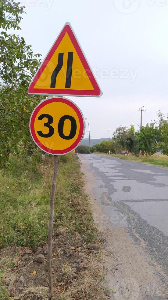 This warning sign for a curvy road includes a speed limit for driver safety and awareness photo