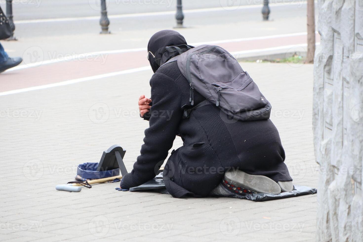 A homeless individual is actively seeking assistance and support in the urban environment photo
