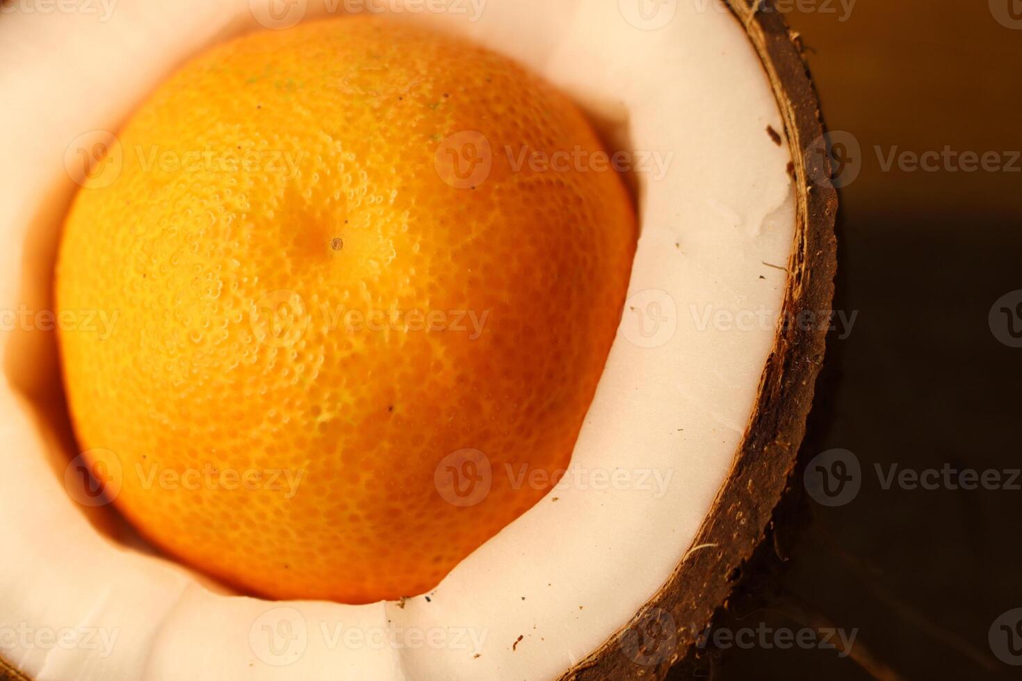 A Fresh Orange Beautifully Displayed Inside a Unique, Split Coconut Shell for a Unique Look photo