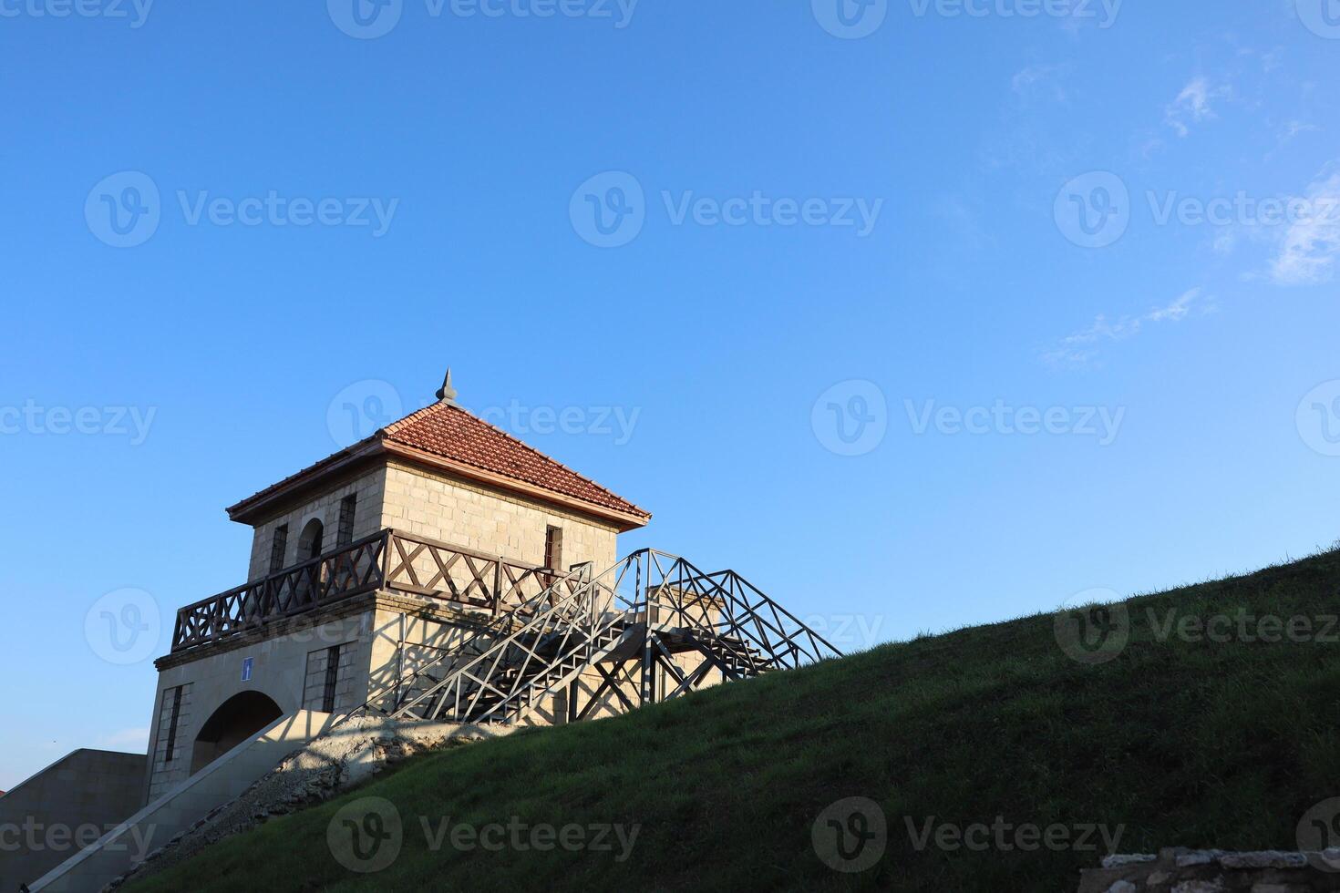 Experience a stunning view of a tower with captivating architecture against a clear blue sky photo