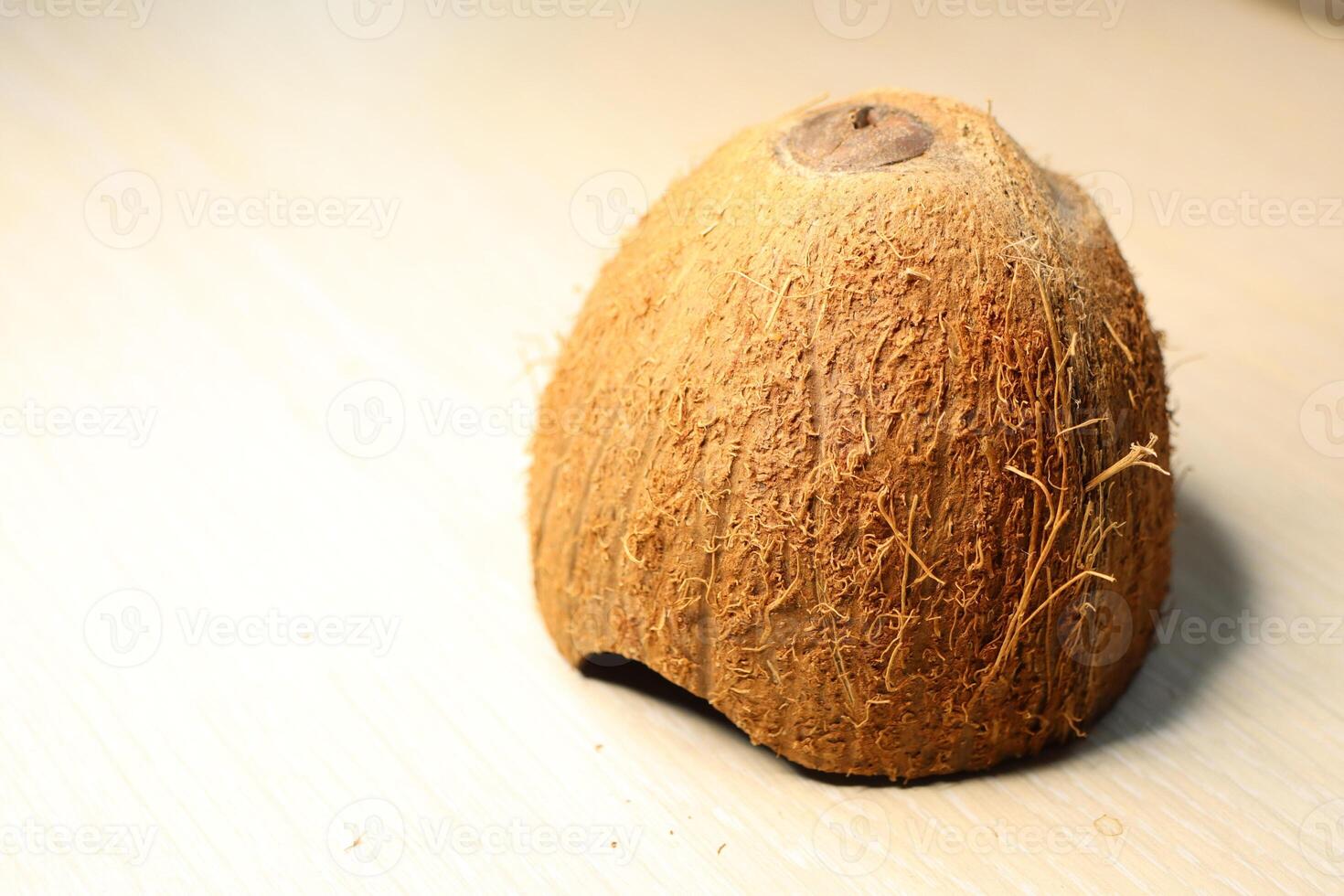 Natural Coconut Shell with Fibers Displayed on a Beautifully Light Surface Background photo