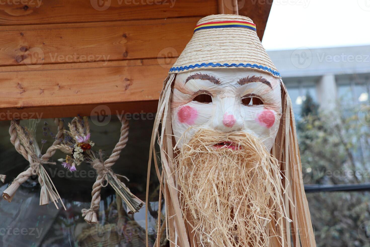 A traditional mask characterized by its unique straw beard and accompanying hat design photo