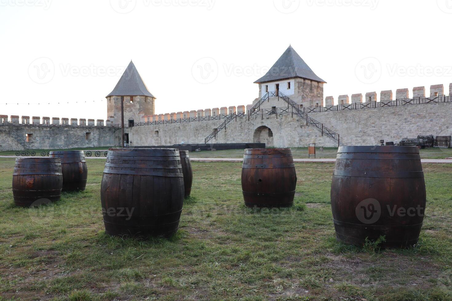 A historic and grand fortress adorned with rustic barrels positioned prominently in front of it photo