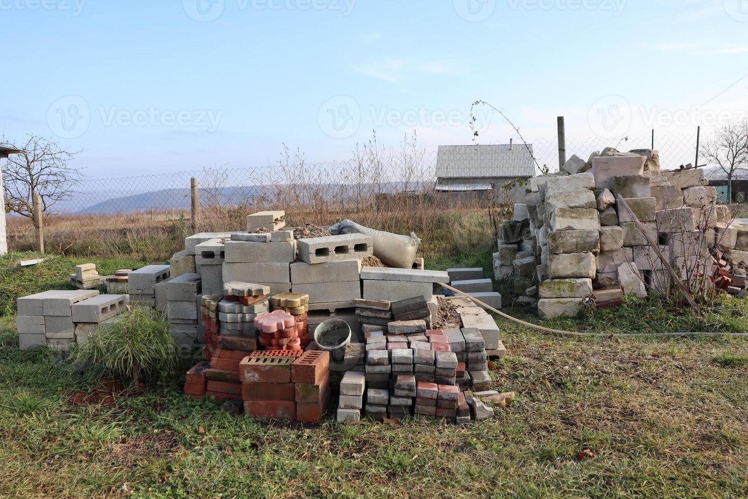 There are piles of untidy concrete blocks and bricks scattered across the open ground area photo
