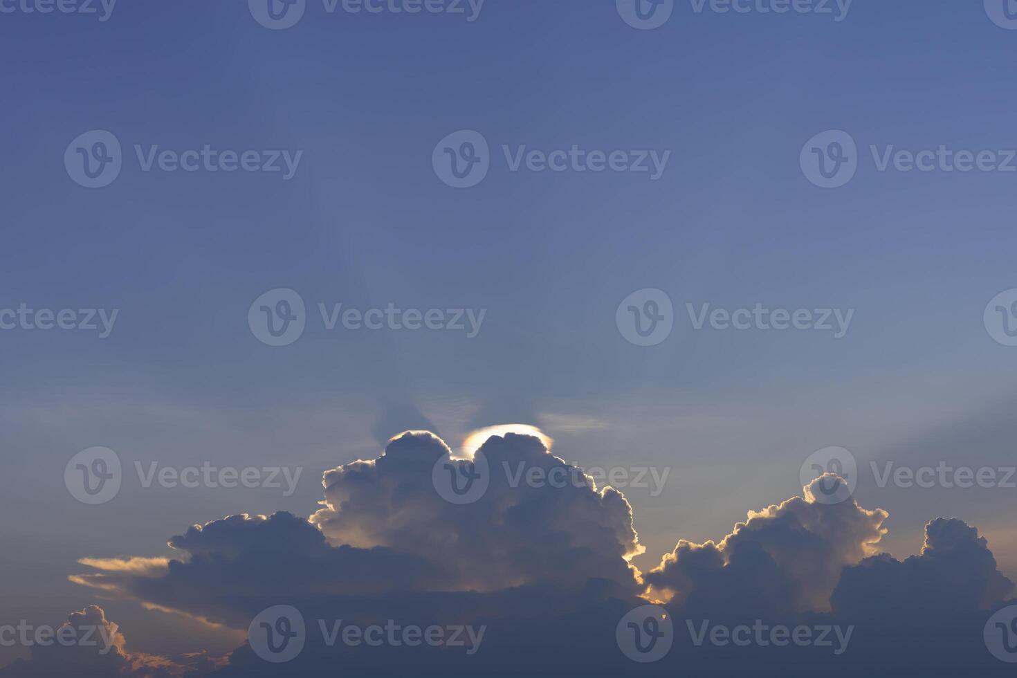 a large cloud with sun rays shining through it photo