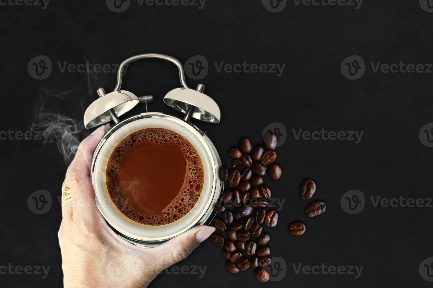 coffee beans and hand with alarm clock on black background photo