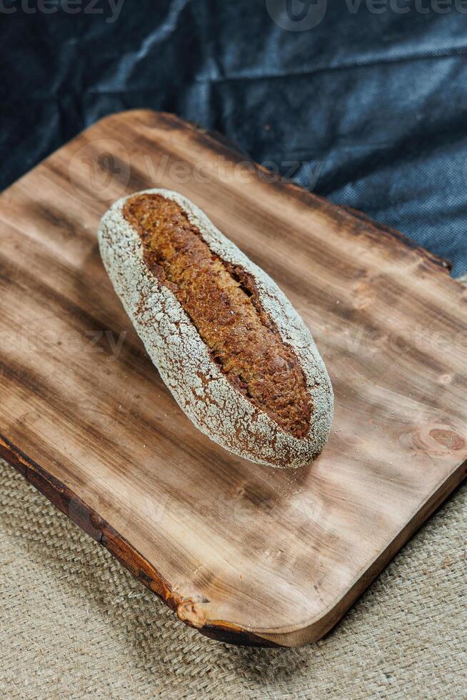 Freshly baked rye bread on yeast-free sourdough and whole grain, rye and wheat flour. It lies on a cut board. photo