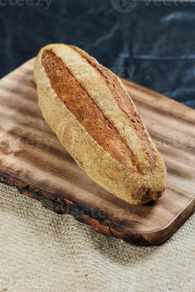 Freshly baked rye bread on yeast-free sourdough and whole grain, rye and wheat flour. It lies on a cut board. photo