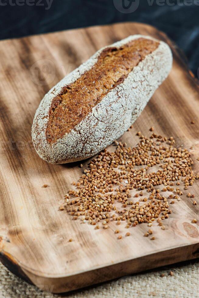 Freshly baked rye bread on yeast-free sourdough and whole grain, rye and wheat flour. It lies on a cut board. photo