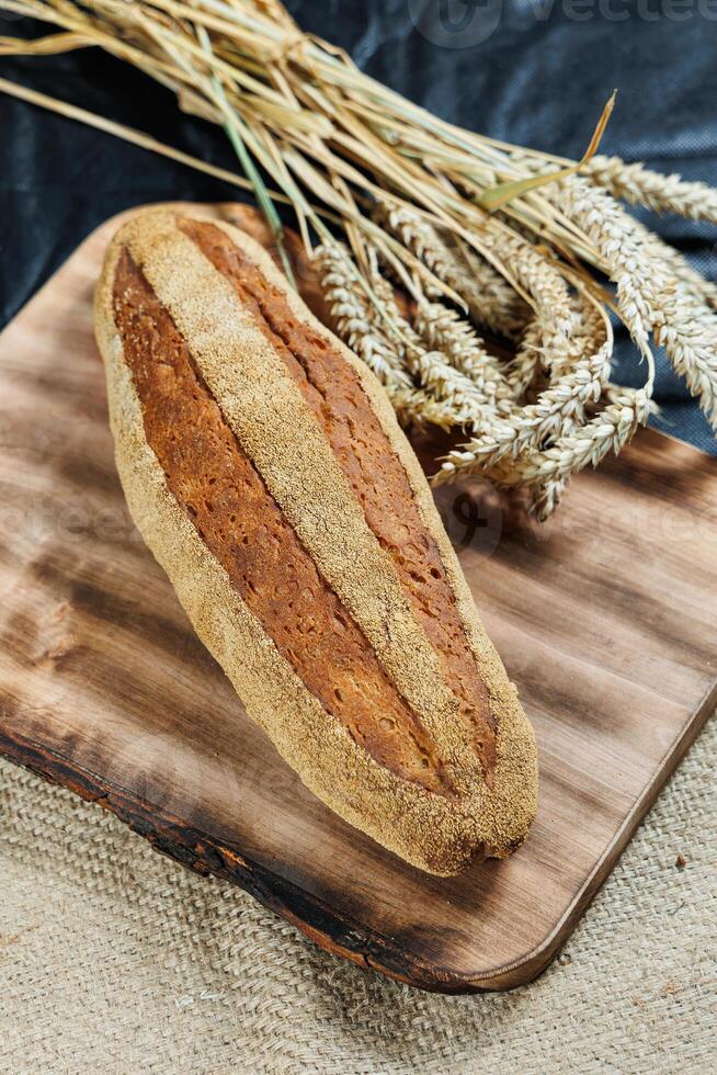 Freshly baked rye bread on yeast-free sourdough and whole grain, rye and wheat flour. It lies on a cut board. photo