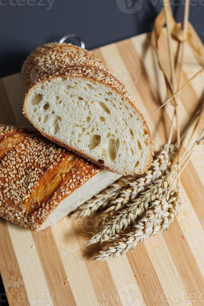 Freshly baked rye bread on yeast-free sourdough and whole grain, rye and wheat flour. It lies on a cut board. photo