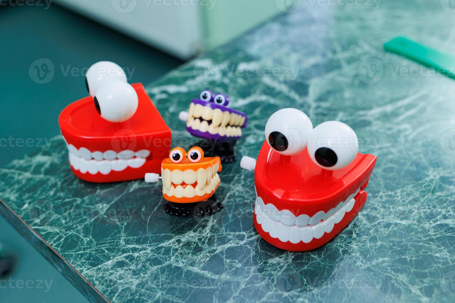 Miniatures of dental artificial jaws with eyes. A plastic model of teeth sits on a table in a dentist's office. photo