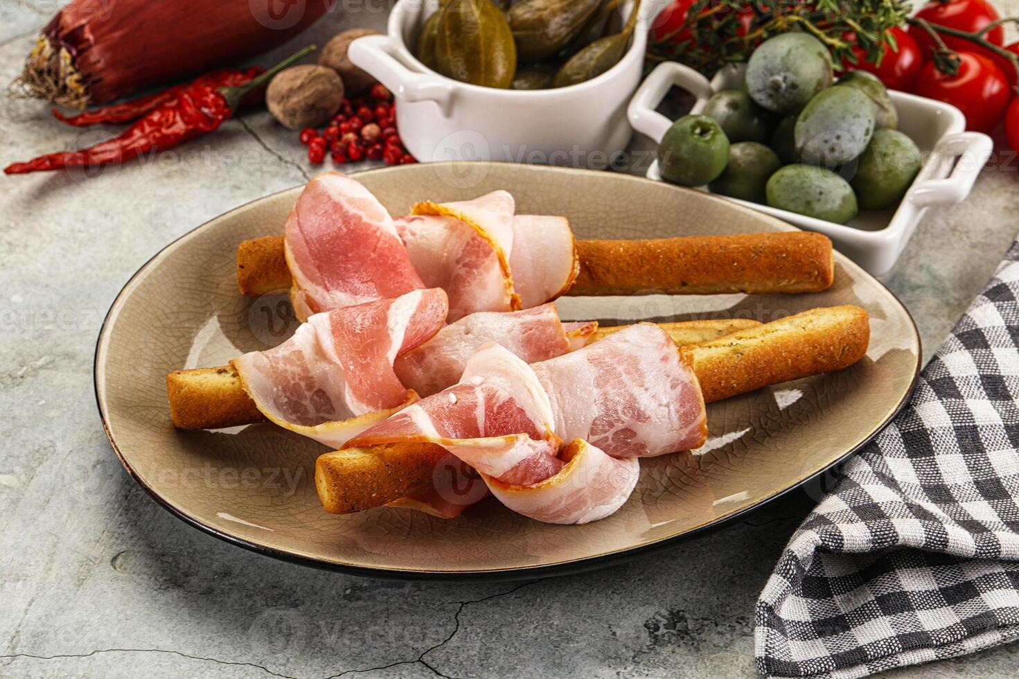 Antipasti - Grissini with pork bacon photo