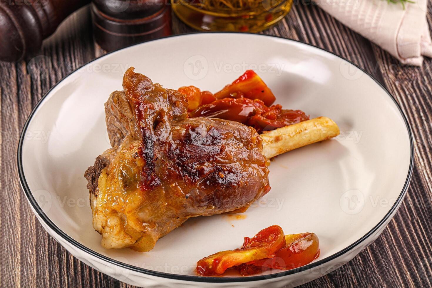 Baked lamb shank with vegetables photo