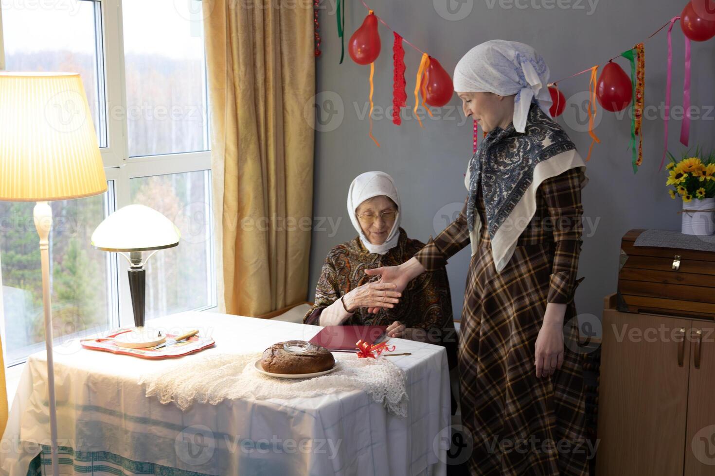 Two women standing near a table with a cake photo