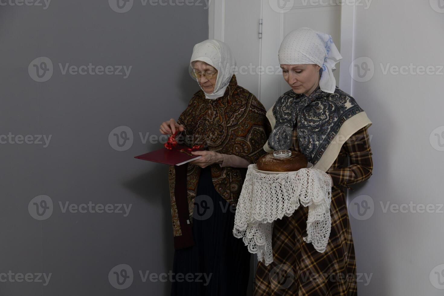 Two women in period clothing standing next to each other photo