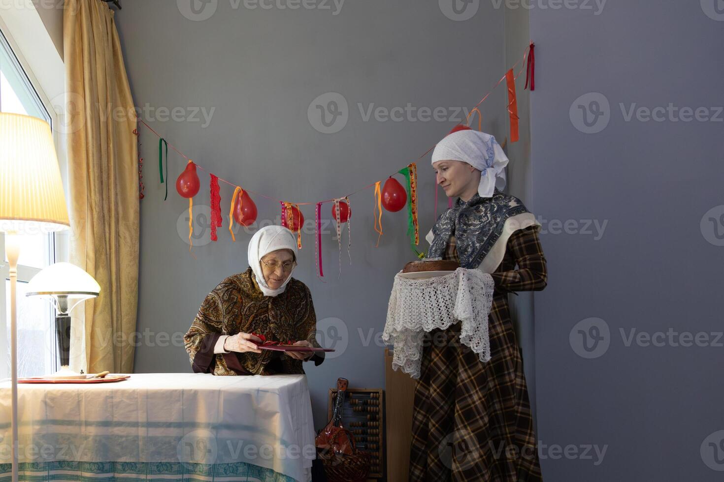 Two women standing next to a table photo