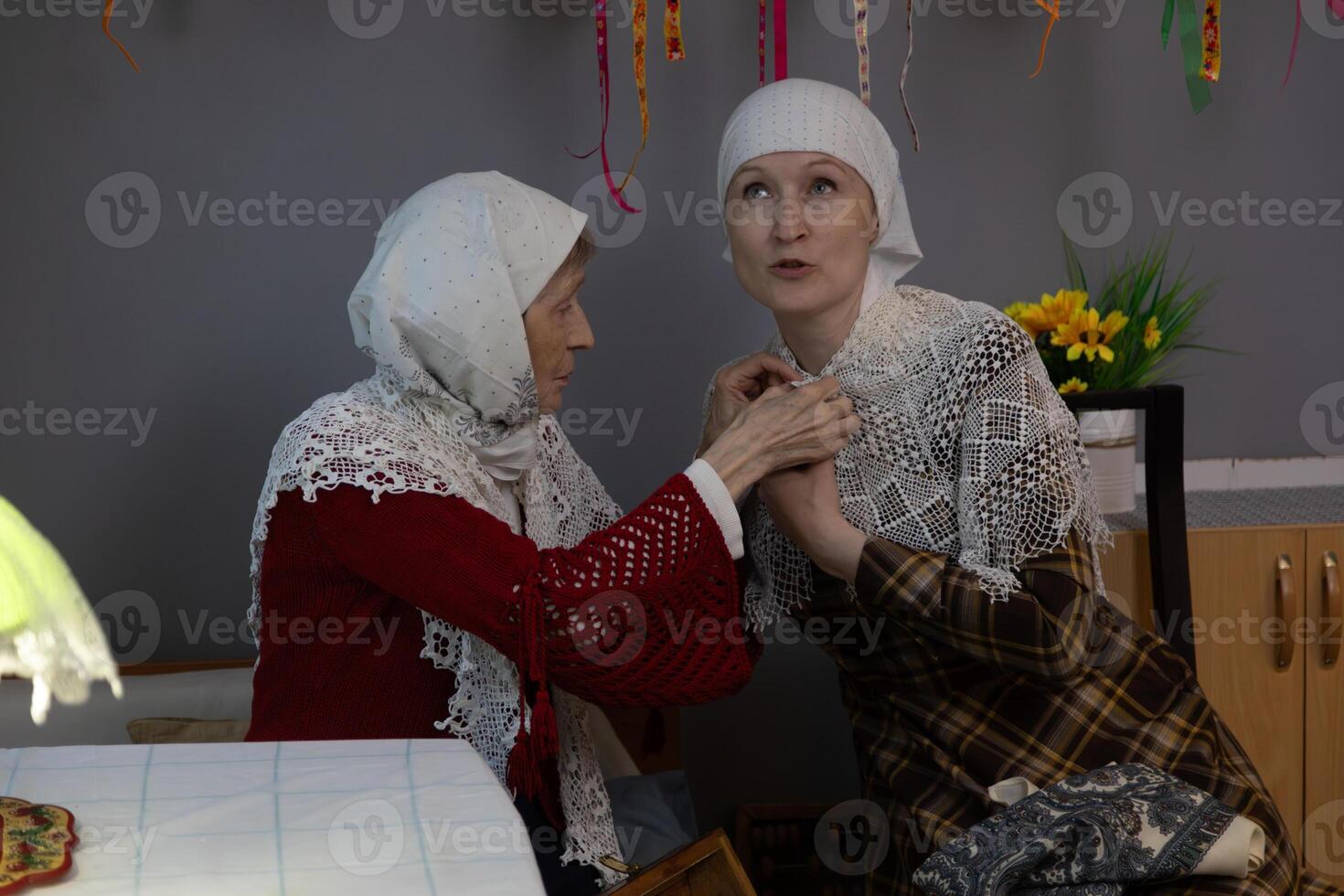 Two women in traditional clothing sitting at a table photo