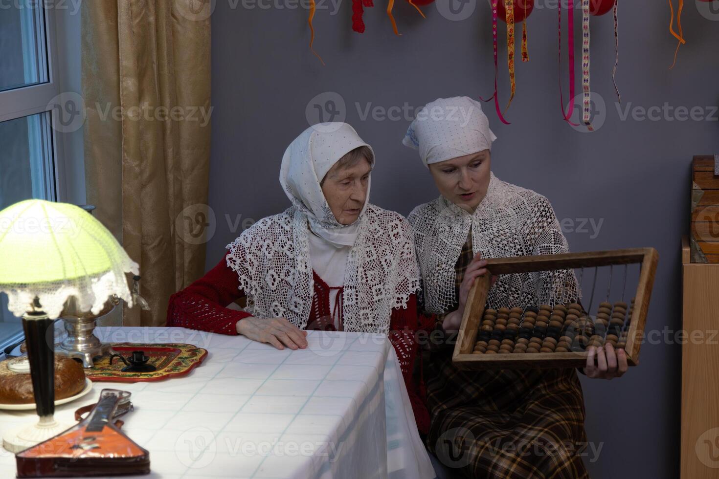 Two women in white headscarves sitting at a table photo