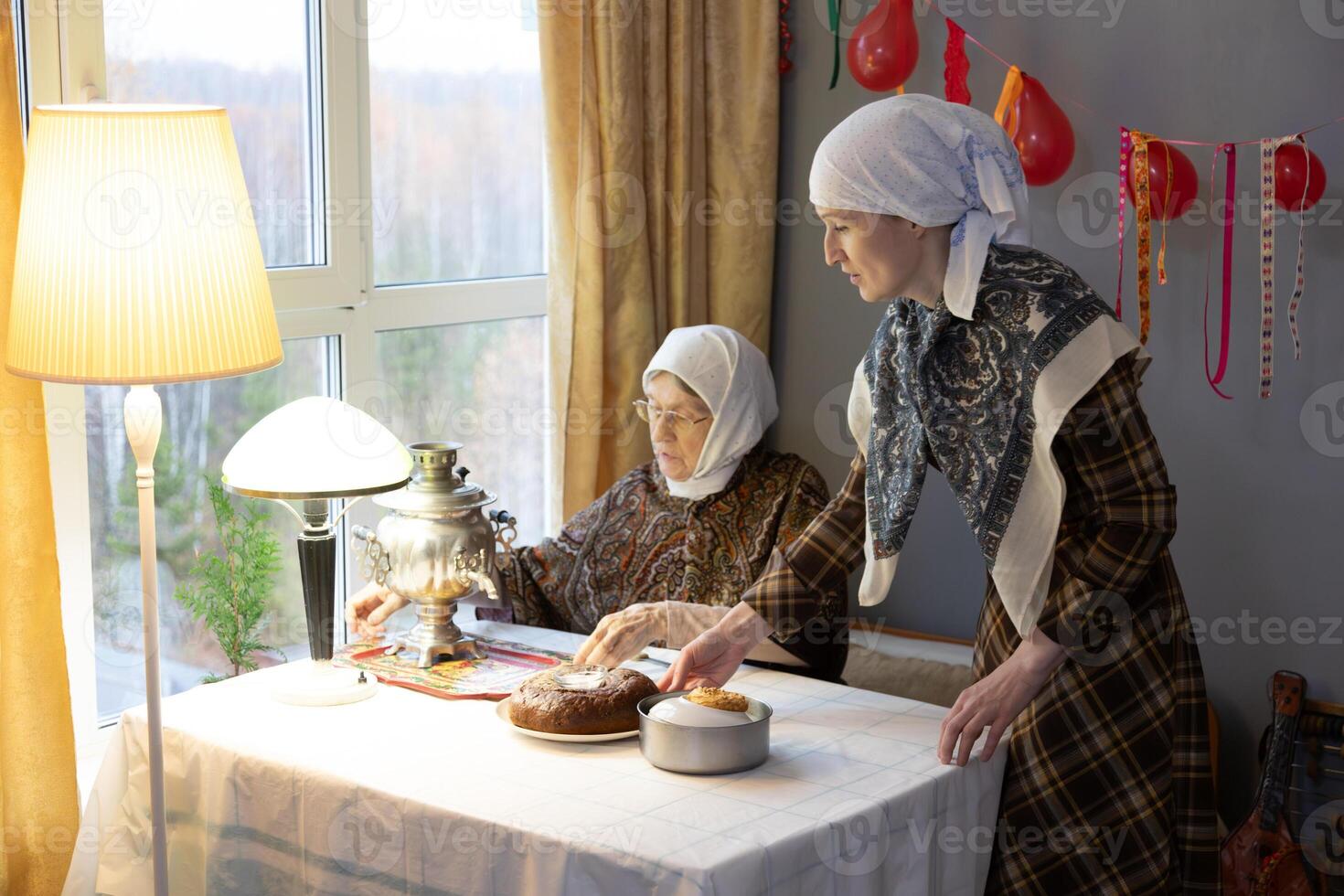 Two women in headscarves sitting at a table photo